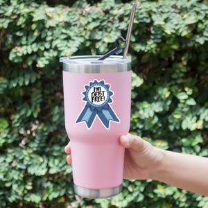 a person holding a pink cup with a straw in it