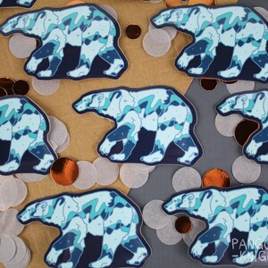May include: Multiple blue and white polar bear stickers with a starry night sky design. The stickers are on a brown and gray background.