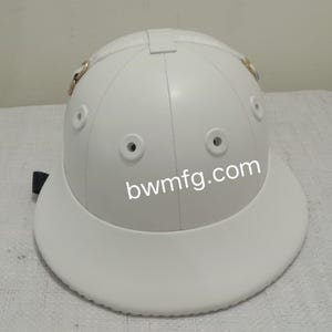 Puede incluir: Casco de equitación de cuero blanco con una visera ancha y una correa. El casco tiene cuatro orificios de ventilación y el texto "bwmfg.com" está impreso en la parte delantera.