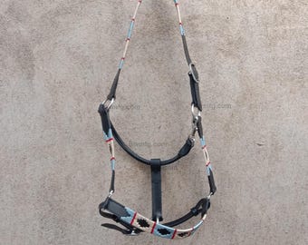 May include: Black leather horse halter with a white, blue and red braided rope design. The halter has a metal buckle and a metal ring. ART # BW-PHC-2