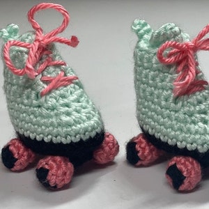 Puede incluir: Un par de patines de ruedas de crochet de color verde claro con cordones rosas y ruedas negras. Los patines son hechos a mano y tienen un diseño lindo y caprichoso.