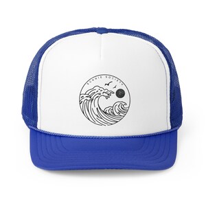 Pu&ograve; includere: Cappellino da camionista blu e bianco con una grafica nera di onde oceaniche, un sole e uccelli all'interno di un cerchio. Il testo "SUNNIE SOCIETY" &egrave; sopra la grafica. Il cappellino ha una tesa blu e un retro in rete.