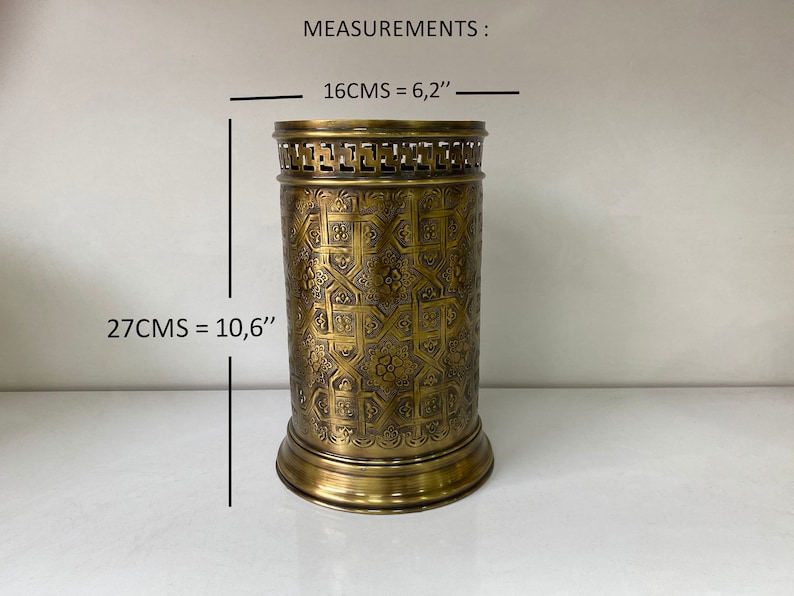 May include: A gold metal umbrella stand with an intricate geometric pattern. The stand is 10.6 inches tall and 6.2 inches wide. MEASUREMENTS: 16CMS = 6,2" 27CMS = 10,6"