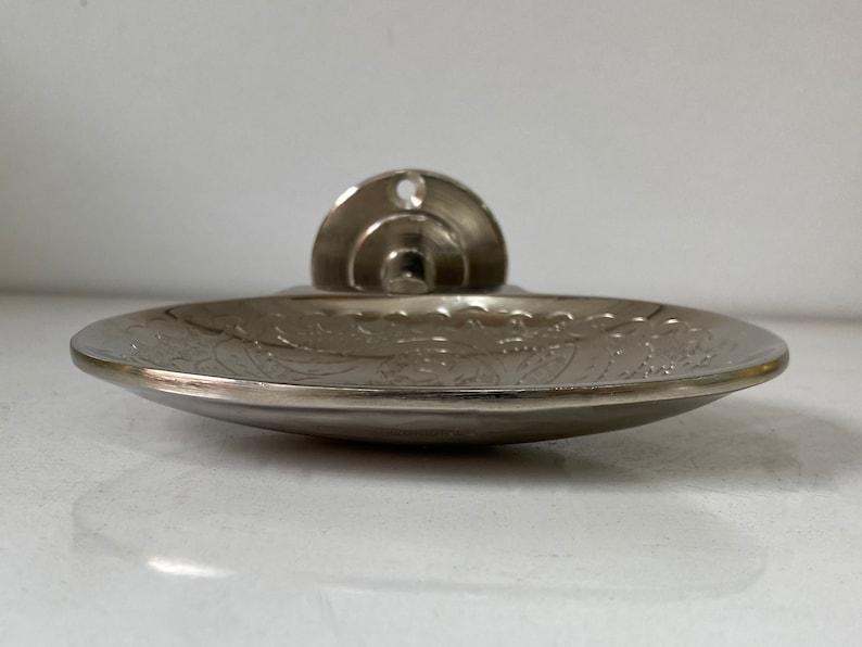 Pu&ograve; includere: Un portasapone in argento con un designo ornato. Il portasapone &egrave; montato a parete con una staffa rotonda.