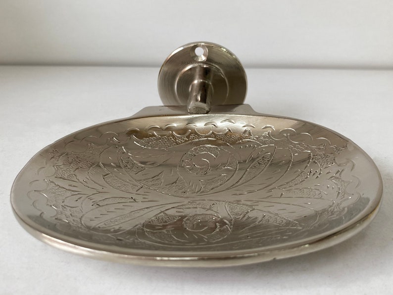 Pu&ograve; includere: Portasapone da parete in argento con un design floreale decorato.