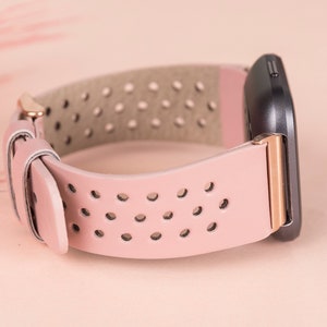 Puede incluir: Una correa de reloj de cuero rosa con hebilla de oro rosa y dise&ntilde;o perforado. La correa es compatible con relojes inteligentes.