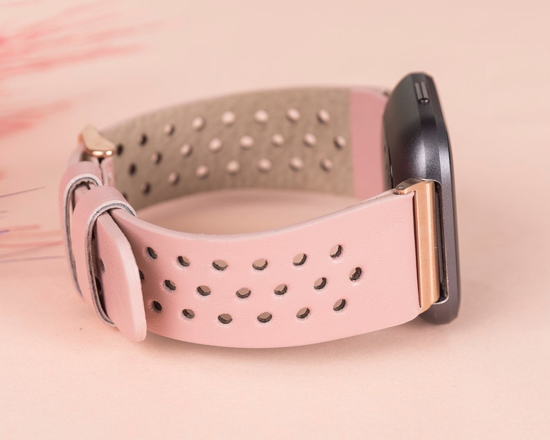 Puede incluir: Una correa de reloj de cuero rosa con hebilla de oro rosa y dise&ntilde;o perforado. La correa es compatible con relojes inteligentes.