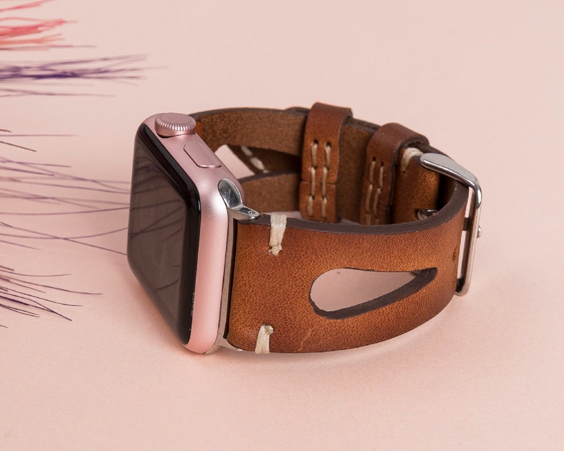 Close-up view of full-grain leather texture and hand stitching on Apple Watch band