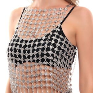 Könnte beinhalten: Ein silbernes Kettenhemd-Oberteil mit Blumenmuster und baumelnden Tropfen-Anhängern. Das Oberteil ist aus Metall und hat einen zarten, femininen Look.