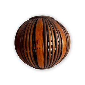 May include: A round, brown wicker lampshade with a woven pattern.