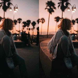 May include: A person wearing a white jacket and blue jeans sits on a concrete ledge. The person is looking to the right. The background is a sunset with palm trees and streetlights.