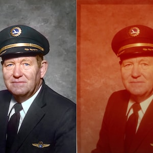 May include: Portrait of a man in a pilot's uniform. He wears a dark blue cap with a gold band and emblem, a dark suit, and a white collared shirt with a black tie. The background is a mottled gray.