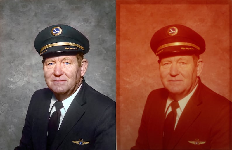 May include: Portrait of a man in a pilot's uniform. He wears a dark blue cap with a gold band and emblem, a dark suit, and a white collared shirt with a black tie. The background is a mottled gray.