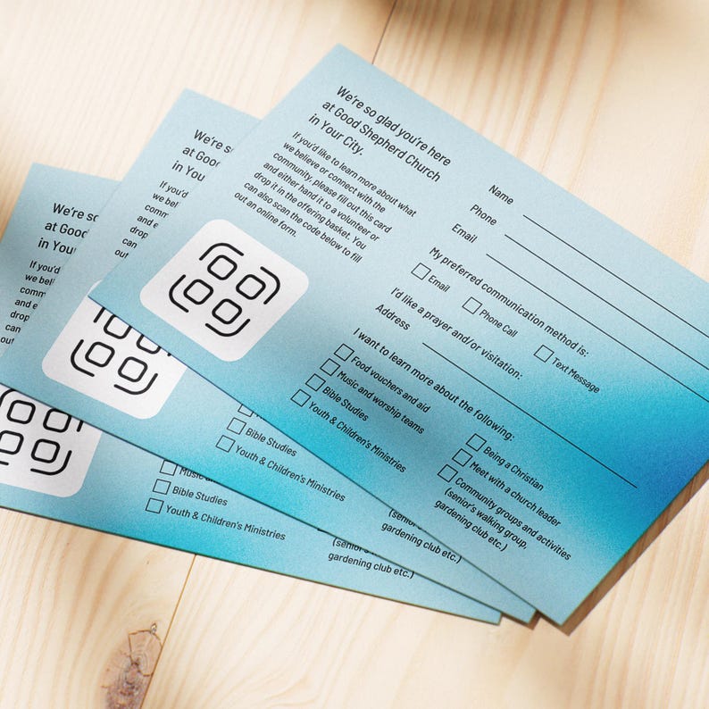 Pode incluir: Pilhas de cart&otilde;es azuis claros com um design gradiente. Cada cart&atilde;o tem um c&oacute;digo QR e campos de texto para nome, telefone e e-mail. Os cart&otilde;es s&atilde;o para a Good Shepherd Church.