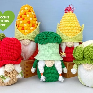 Puede incluir: Cinco gnomos de crochet, cada uno con una verdura diferente en la cabeza. Los gnomos están hechos en tonos de rojo, verde y amarillo. Los gnomos están sentados sobre una superficie de madera. CROCHET PATTERN PDF.