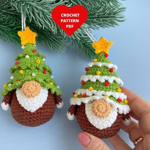 Puede incluir: Dos gnomos de árbol de Navidad de crochet con cuerpos de fieltro marrón, barbas de fieltro blanco y sombreros de fieltro verde decorados con cuentas rojas y amarillas. Los gnomos están colgados de una rama.