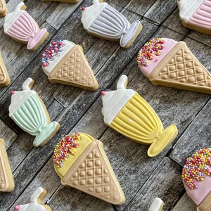 May include: Assortment of iced cream and milkshake themed sugar cookies decorated with colorful sprinkles and frosting.