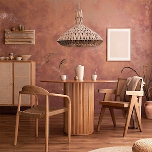 May include: A round wooden dining table with a woven rattan base and two woven rattan chairs. A woven rattan pendant light hangs above the table. The room has a warm, earthy color scheme.