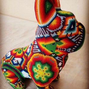 May include: A colorful beaded figurine of a dog, with intricate patterns in shades of red, orange, yellow, green, blue, and white.