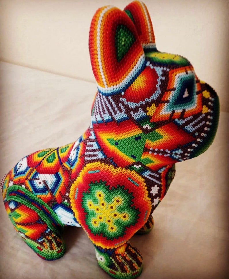 May include: A colorful beaded figurine of a dog, with intricate patterns in shades of red, orange, yellow, green, blue, and white.