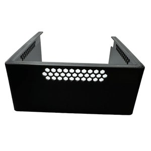 May include: Black plastic case with a honeycomb pattern on the front and sides. The case is open on the top and bottom.