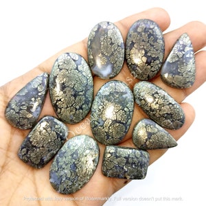 Könnte beinhalten: Eine Sammlung von 10 Cabochon-Edelsteinen mit einem silbernen und grauen dendritischen Achatmuster. Die Cabochons haben verschiedene Formen und Größen, darunter ovale, tropfenförmige und rechteckige.