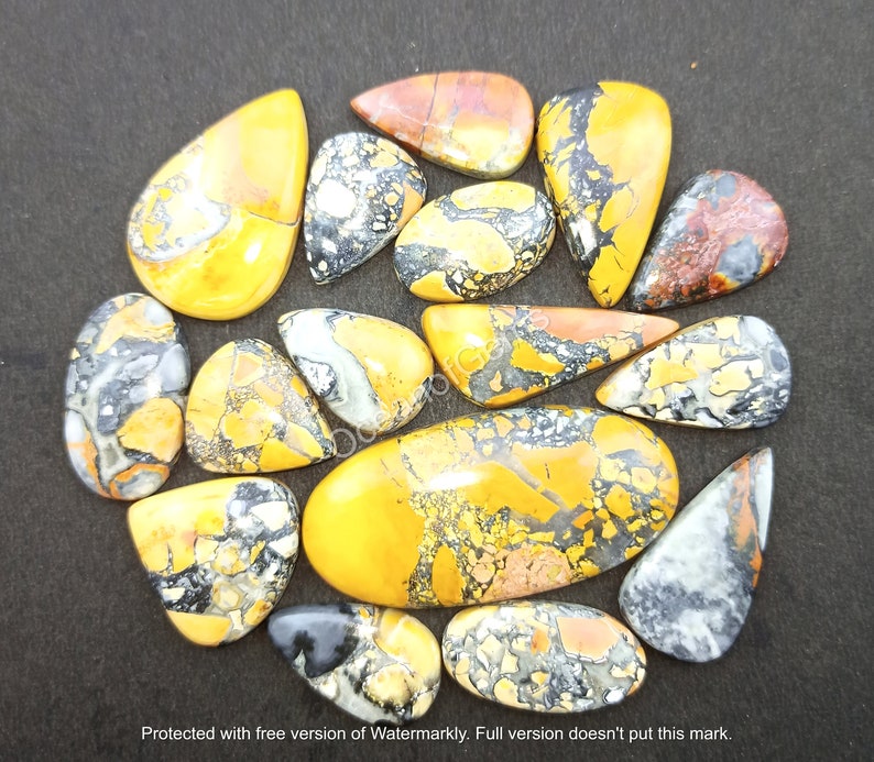 Puede incluir: Una colecci&oacute;n de 15 cabujones de piedras preciosas amarillas, naranjas y negras. Los cabujones son de varias formas y tama&ntilde;os, algunos tienen forma de l&aacute;grima. Los cabujones est&aacute;n todos pulidos y tienen un acabado liso y brillante.