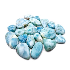 May include: A collection of 15 blue and white ocean jasper cabochons, each with a unique pattern and shape. The stones are smooth and polished, with a variety of sizes and shapes.