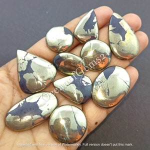 Op de afbeelding: Assortiment van tien natuurlijke pyriet cabochons in verschillende vormen en maten. De cabochons zijn een mix van gouden en zwarte kleuren met een metallic glans.