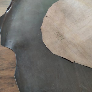 May include: Two pieces of leather, one dark brown and one light brown. The light brown piece has the number "0055" written on it.
