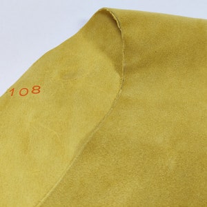 May include: A close-up of a piece of yellow fabric with the number "108" printed on it.