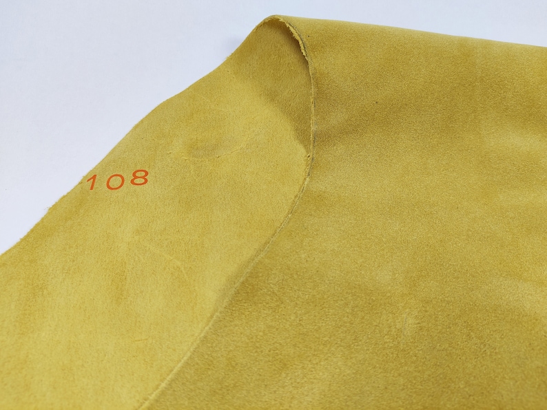May include: A close-up of a piece of yellow fabric with the number "108" printed on it.
