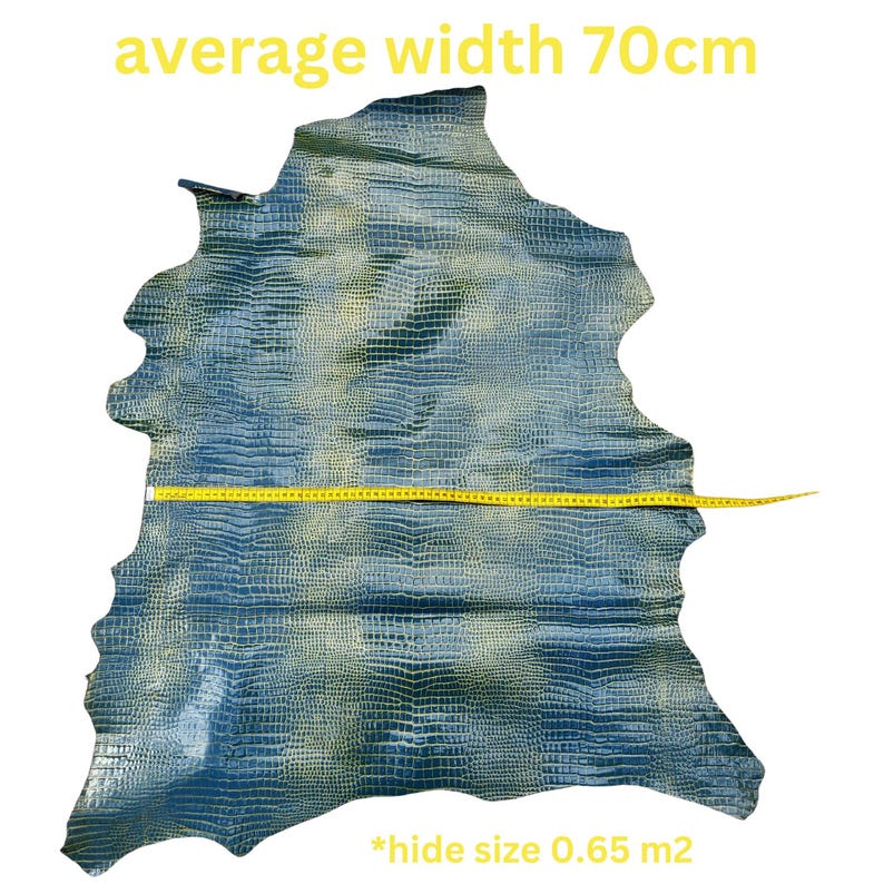 May include: A blue and green crocodile hide with a yellow measuring tape across the middle. The tape reads "average width 70cm". The text "*hide size 0.65 m2" is at the bottom of the image.