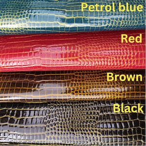 May include: Four swatches of faux leather in different colors: petrol blue, red, brown, and black. Each swatch has a crocodile-embossed pattern.