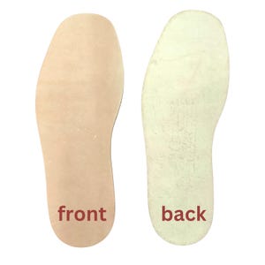 May include: Two insoles, one light tan and one off-white, are displayed against a white background. The light tan insole has the word "front" in red text. The off-white insole has the word "back" in red text. The insoles are shoe inserts.