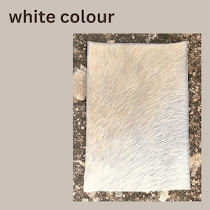 May include: A rectangular, off-white cowhide rug with a soft, textured surface. The rug has a natural, organic look with variations in the white color. The words "white colour" are in the top left corner.