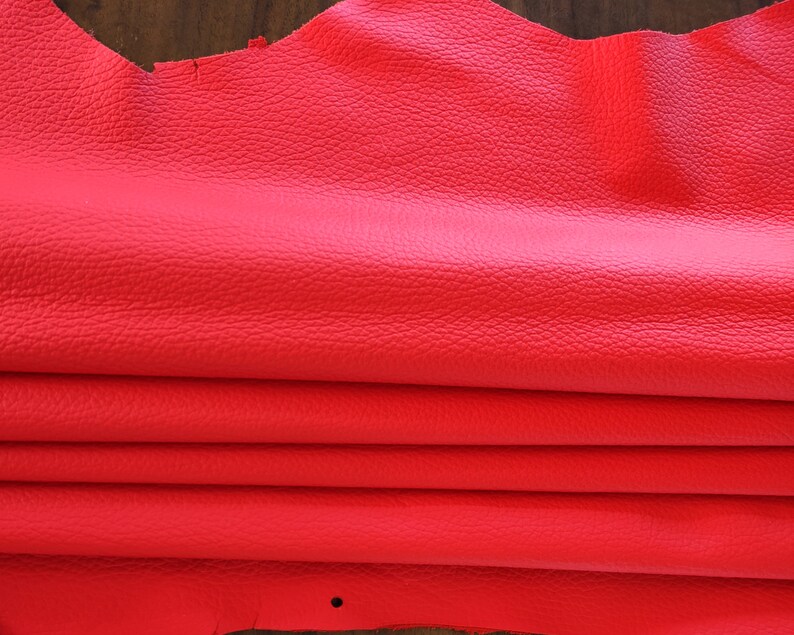 May include: A folded piece of bright red leather. The leather has a textured surface.