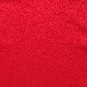 May include: Close-up of a red textured fabric with a slightly grainy surface.