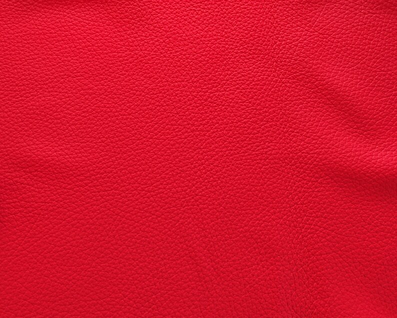 May include: Close-up of a red textured fabric with a slightly grainy surface.