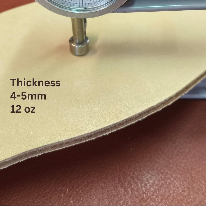 May include: Close-up of a piece of light tan leather being measured with a caliper. The text on the leather reads "Thickness 4-5mm 12 oz."