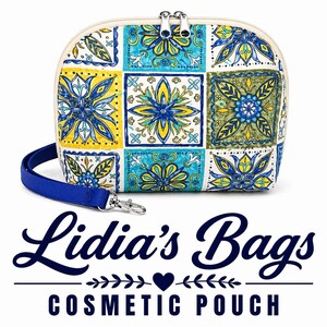 May include: Cosmetic pouch with a colorful floral tile pattern in yellow, blue, and green. The pouch has a white background, a blue wrist strap, and a silver zipper. The text "Lidia's Bags COSMETIC POUCH" is below the pouch.