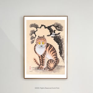 May include: Framed artwork depicting a tiger with orange and black stripes, yellow eyes, and a white muzzle. A black and white bird perches on a tree branch above the tiger. The artwork is in a wooden frame.