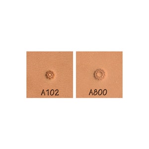 May include: Two leathercraft stamps, each with a floral design. One is labeled "A102" and the other "A800". The stamps are pressed into a light brown leather surface, showcasing the detailed floral patterns.