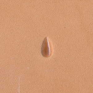 May include: A close-up of a light brown leather surface with a single teardrop-shaped impression.