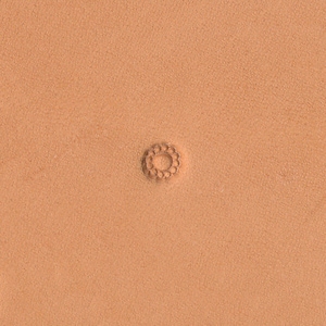 May include: A close-up of a light brown leather surface with a small, circular, decorative design embossed in the center. The design is made up of a series of small, evenly spaced circles.