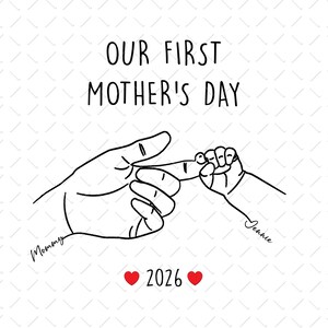 May include: A black and white line drawing with the text "OUR FIRST MOTHER'S DAY". The image depicts an adult hand holding a baby's finger, with the names "Mommy" and "Jennie" and the year "2026". Two red hearts are also included.