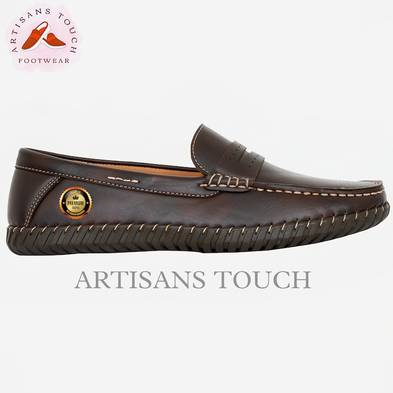 May include: Brown leather loafers with a stitched edge and a textured sole. The shoes have a gold label with the text "PREMIUM" and a crown. The brand name "ARTISANS TOUCH" is printed on the bottom of the shoe.