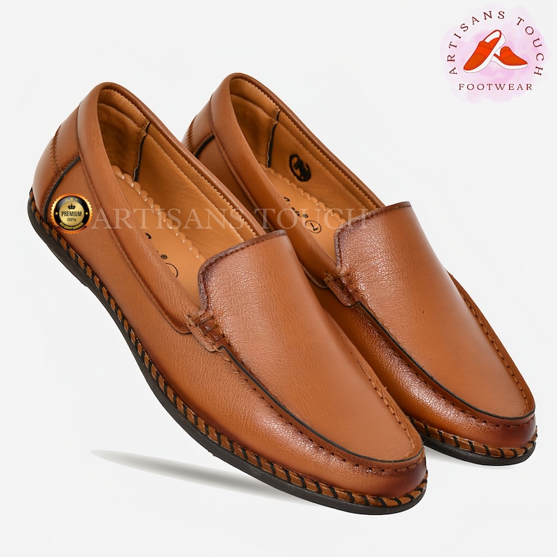 May include: A pair of brown leather loafers with a stitched edge. The loafers have a simple design and are made of a soft, supple leather.