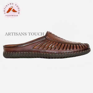 May include: Brown leather slip-on sandals with a woven design and a brown rubber sole. The sandals have a stitched detail around the edge of the sole. The brand name "ARTISANS TOUCH" is printed on the top of the sandal.