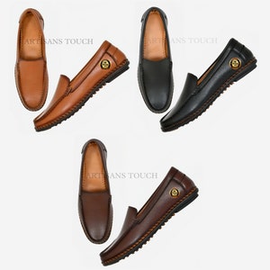 May include: Three pairs of leather loafers in brown, black, and dark brown. Each pair features a gold button detail and a stitched trim around the sole.
